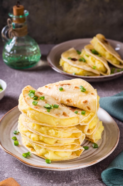 Una pila di focaccia sottile Kystyby ripiena di purè di patate e cipolle su un piatto Vista verticale