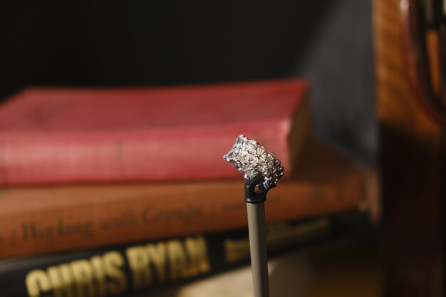 una pila di libri con un anello di diamanti in cima