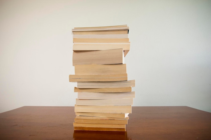 Foto una pila di libri sul tavolo contro la parete