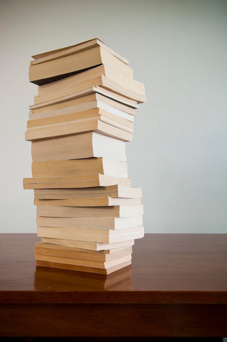 Foto una pila di libri sul tavolo contro la parete
