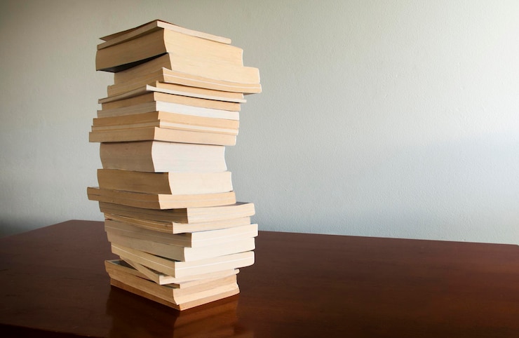 Foto una pila di libri sul tavolo contro la parete
