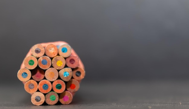 Una pila di matite colorate su sfondo nero