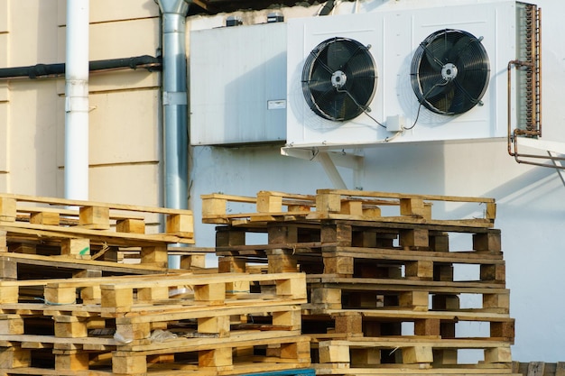 Una pila di pallet di legno in un magazzino interno Un'area di stoccaggio di pallet all'aperto sotto il tetto accanto al negozio Pile di pallet da carico Eurotype in un impianto di riciclaggio dei rifiuti