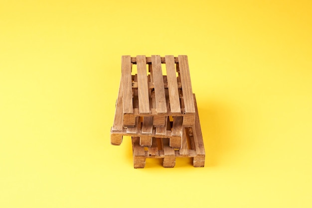 Una pila di pallet di legno su uno sfondo giallo