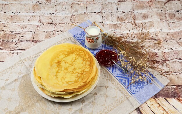 Una pila di pancake con panna acida e latte