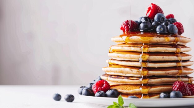 Una pila di pancake di cereali integrali con bacche e sciroppo d'acero