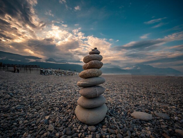 Una pila di pietre sulla spiaggia contro il cielo durante il tramonto