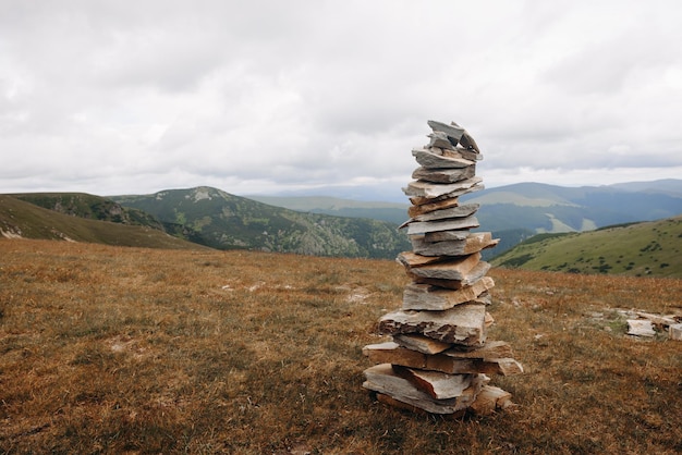 Una pila di rocce in cima a una montagna con le montagne sullo sfondo.