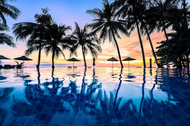 Una piscina con palme e un tramonto sullo sfondo