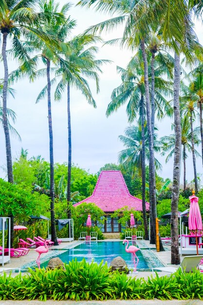 Una piscina vivace con palme di fenicotteri rosa e una capanna rosa