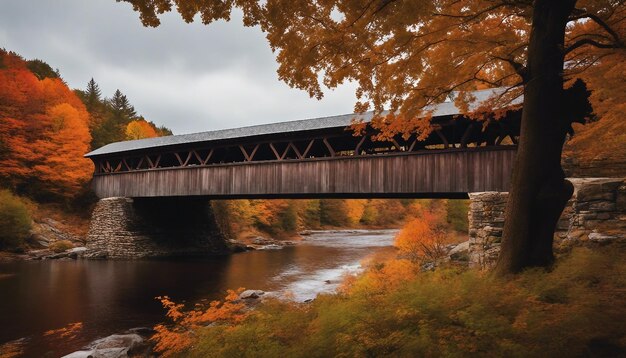 Una pittoresca scena autunnale del New England con fogliame fiammeggiante un ponte coperto e un fiume meandrante