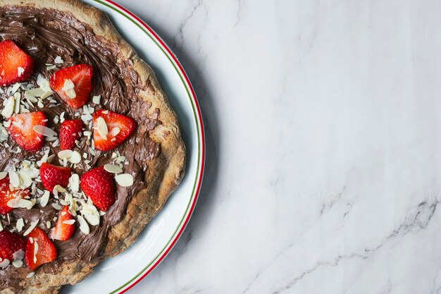 Una pizza al cioccolato con fragole e mandorle con spazio per il testo