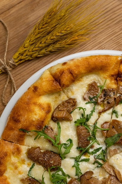 Una pizza con funghi affettati e cipolle verdi