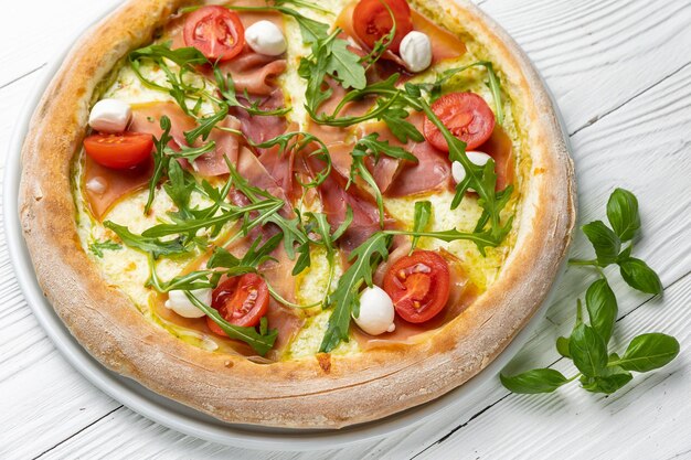 Una pizza con rucola e mozzarella sopra