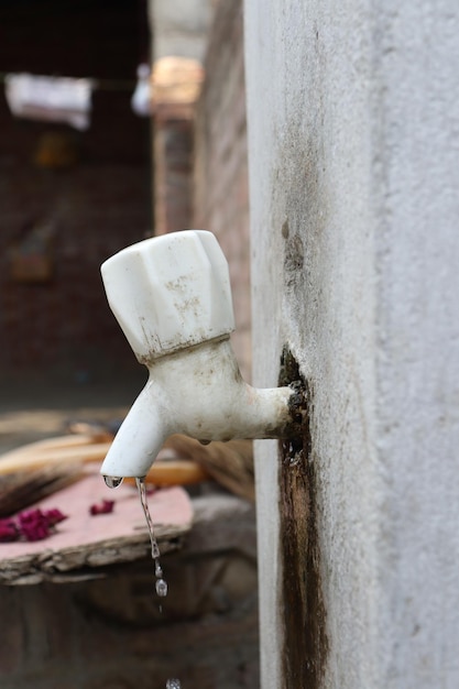 Una pompa a mano viene utilizzata per pompare l'acqua da un rubinetto