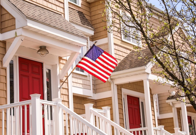 Una porta rossa è aperta su un balcone con sopra una bandiera americana.