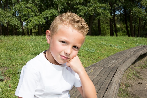 Una posa bionda allegra del bambino del ragazzo da dieci anni all&#39;aperto