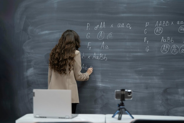 una professoressa asiatica che tiene la lezione online con traduzione utilizzando lo smartphone