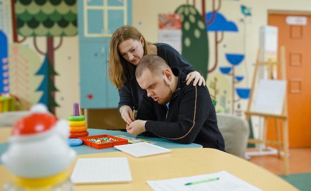 Una psicologa lavora con un ragazzo adulto con autismo in ufficio