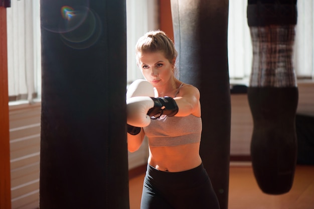 Una pugile si allena duramente in uno studio di boxe.