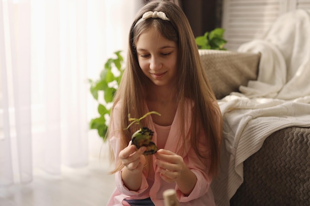 una ragazza a casa ha un seme di mango in un vaso di fiori istruzioni passo passo passo due