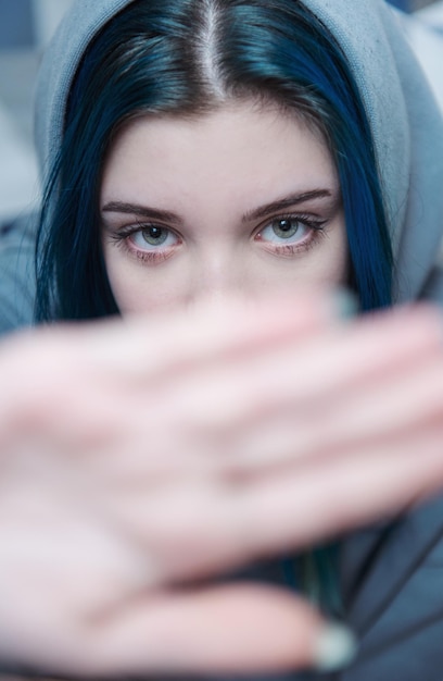 Una ragazza adolescente con i capelli blu si copre il viso con la mano Protesta adolescenziale Depressione