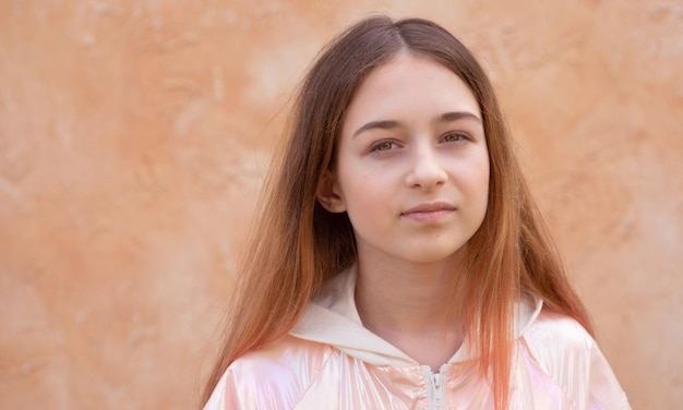 Una ragazza adolescente in una giacca rosa su sfondo beige Ritratto di una bella ragazza