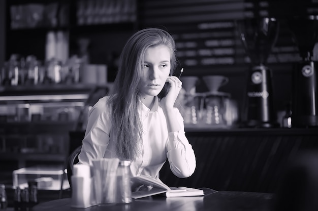 Una ragazza al bar sta bevendo il caffè. Una donna sta facendo colazione in un ristorante. Caffè mattutino nella caffetteria per la ragazza.