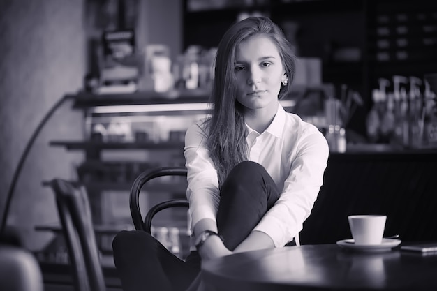 Una ragazza al bar sta bevendo il caffè. Una donna sta facendo colazione in un ristorante. Caffè mattutino nella caffetteria per la ragazza.