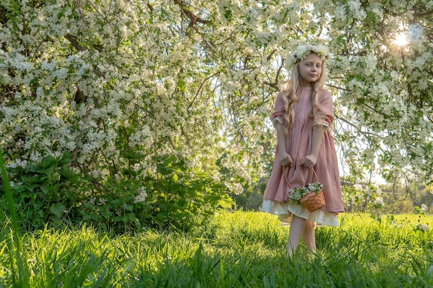 Una ragazza annusa una bella primavera di melo bianco nel mezzo della fioritura del melo è