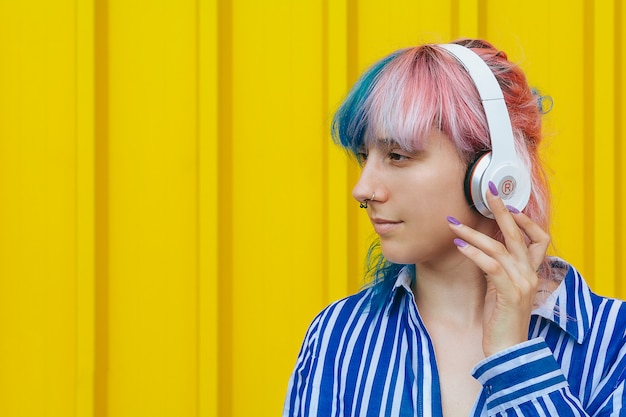 Una ragazza ascolta la sua musica preferita in grandi cuffie bianche