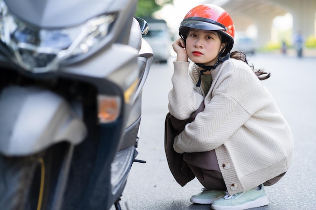 Una ragazza asiatica ha rotto la sua moto mentre andava al lavoro