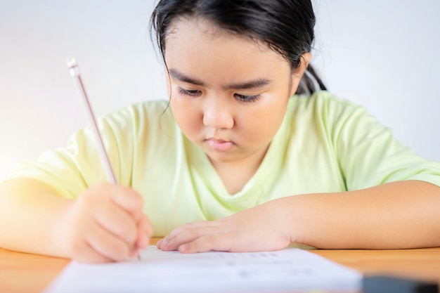 Una ragazza asiatica sta facendo la pratica dei compiti facendo esercizi di potenziamento delle abilità Torna al concetto di scuola