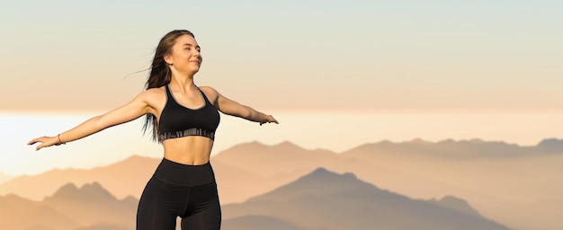 Una ragazza atletica magra fa una pausa tra le lezioni sullo sfondo delle montagne al mattino presto gode di silenzio e libertà