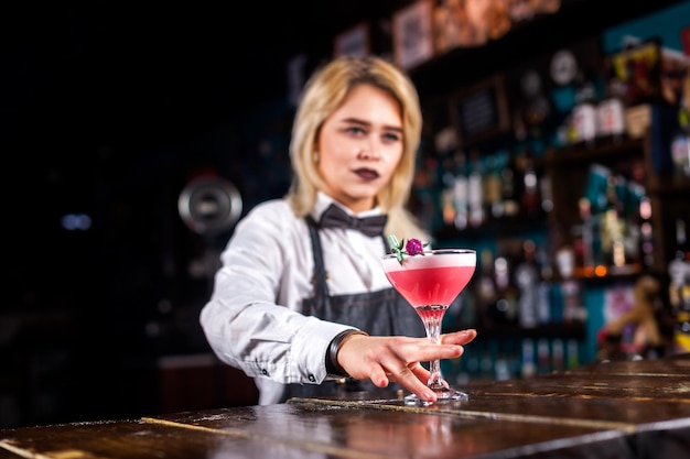 Una ragazza barista prepara un cocktail al pub