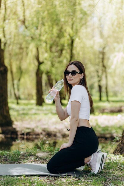 una ragazza beve acqua dopo lo sport