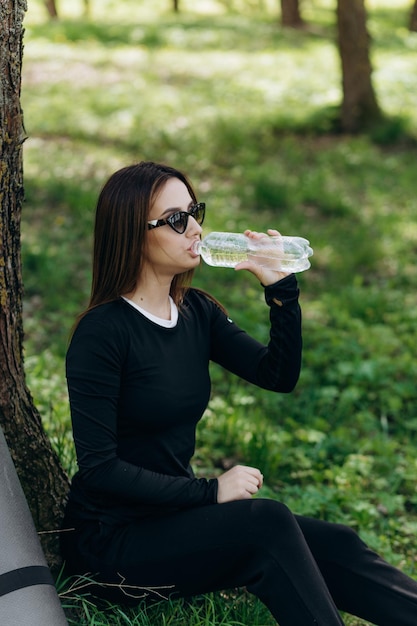 una ragazza beve acqua dopo lo sport