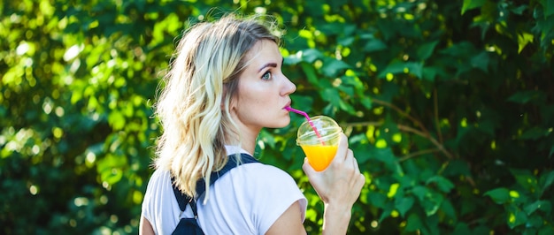 Una ragazza beve succo appena spremuto, uno stile di vita sano Concetto di banner.