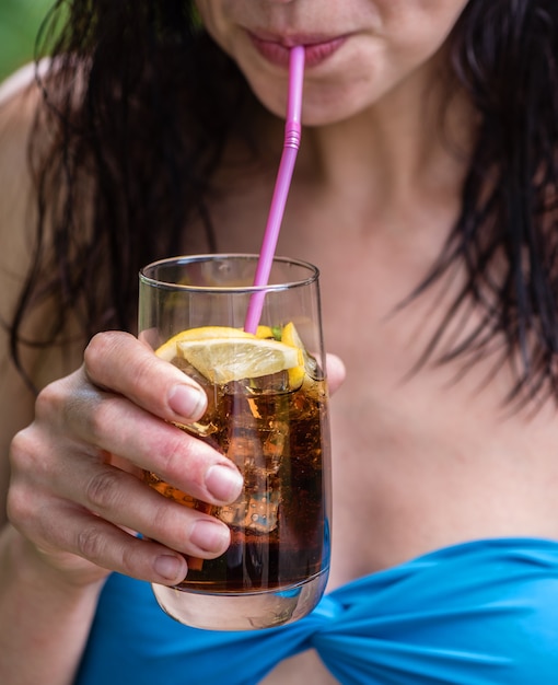 Una ragazza beve un cocktail all'aperto