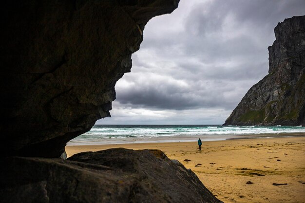 una ragazza cammina da sola sulla famosa spiaggia di kvalvika sulle isole lofoten in norvegia la famosa spiaggia