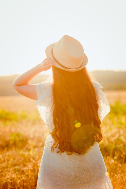 Una ragazza cammina in un campo al sole