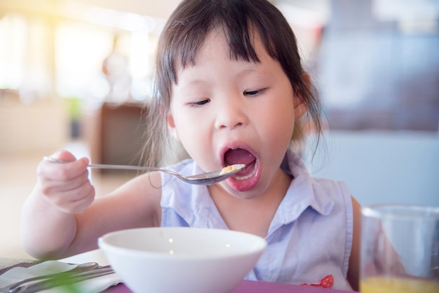 Una ragazza carina che fa colazione a casa