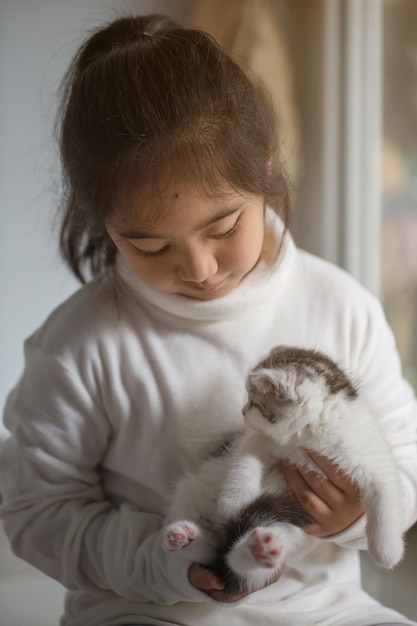 Una ragazza carina che tiene un gattino