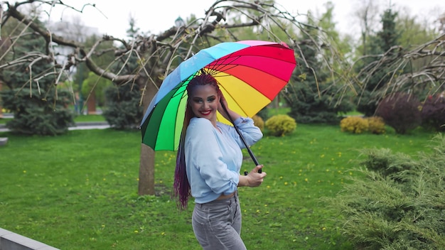 Una ragazza carina con trecce multicolori e trucco luminoso