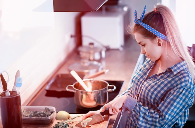 Una ragazza carina in cucina prepara la cena