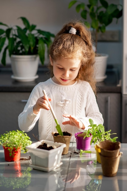 Una ragazza carina pianta a casa in vasi ecologici Il giardino di casa Hobby