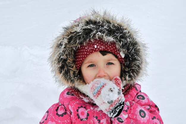 Una ragazza che gioca con la neve in inverno.