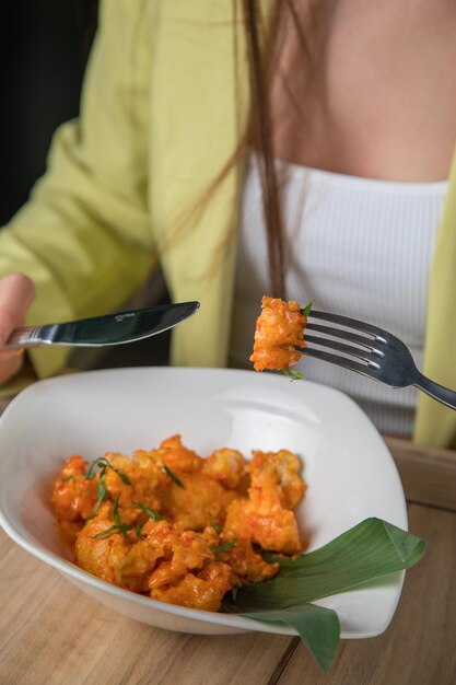 Una ragazza che mangia con un cucchiaio Donna in giallo mangia grano saraceno donna che mangia yogurt gustoso a casa