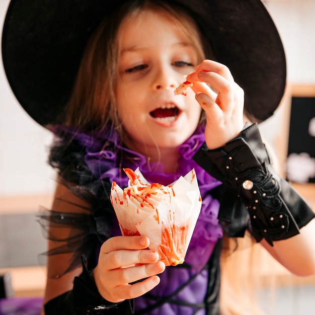Una ragazza che mangia dolci a una festa di Halloween