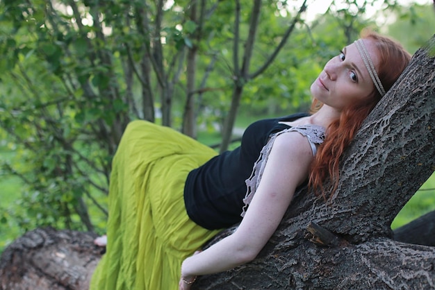 Una ragazza che passeggia in un parco autunnale. Giovane ragazza dai capelli rossi in primavera sulla natura.